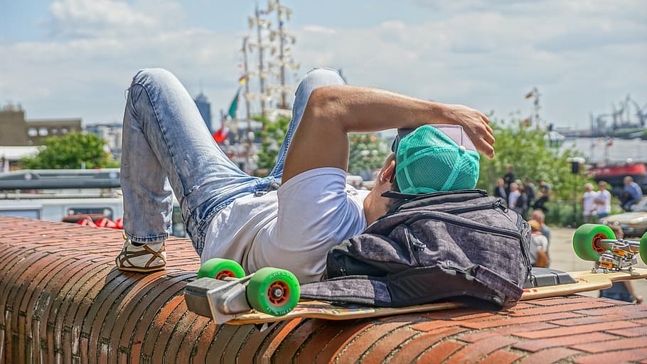 man in white shirt lying on brown frame during daytime, hamburg HD wallpaper
