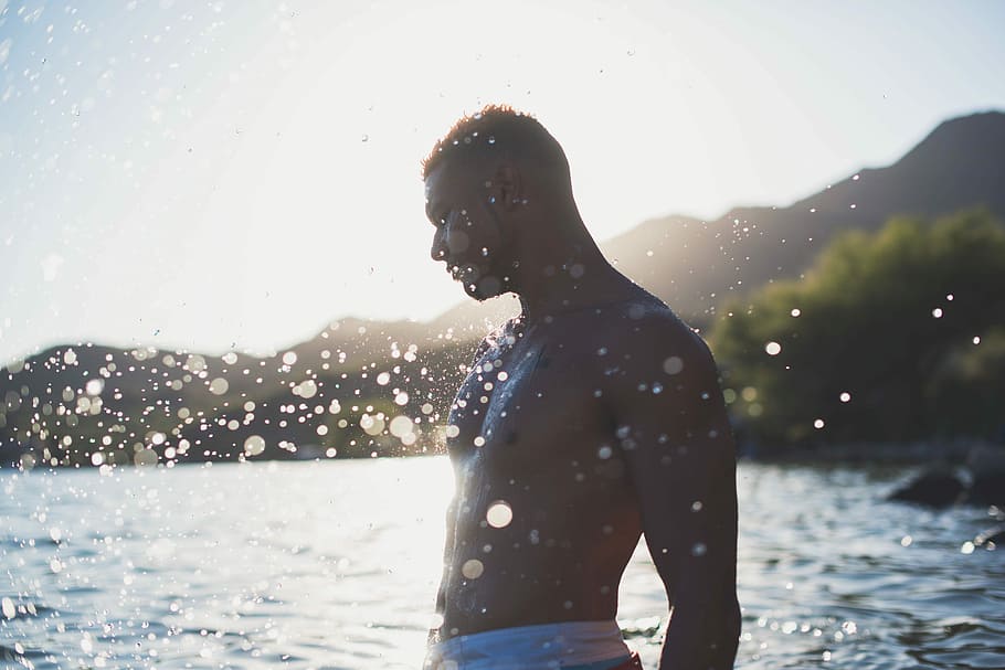 man standing on shallow body of water during daytime, nikon HD wallpaper