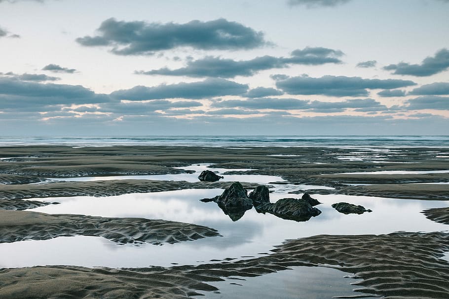 sand field with water, body of water beside stones, lowtide, seaside HD wallpaper