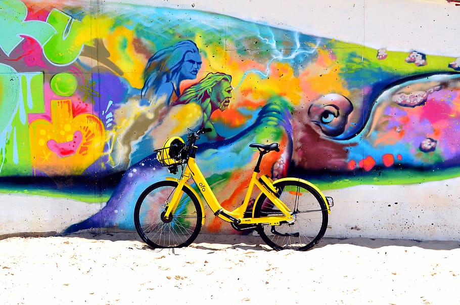 green bicycle park beside wall with human painting during daytime, yellow bicycle placed near wall with grafitti, HD wallpaper