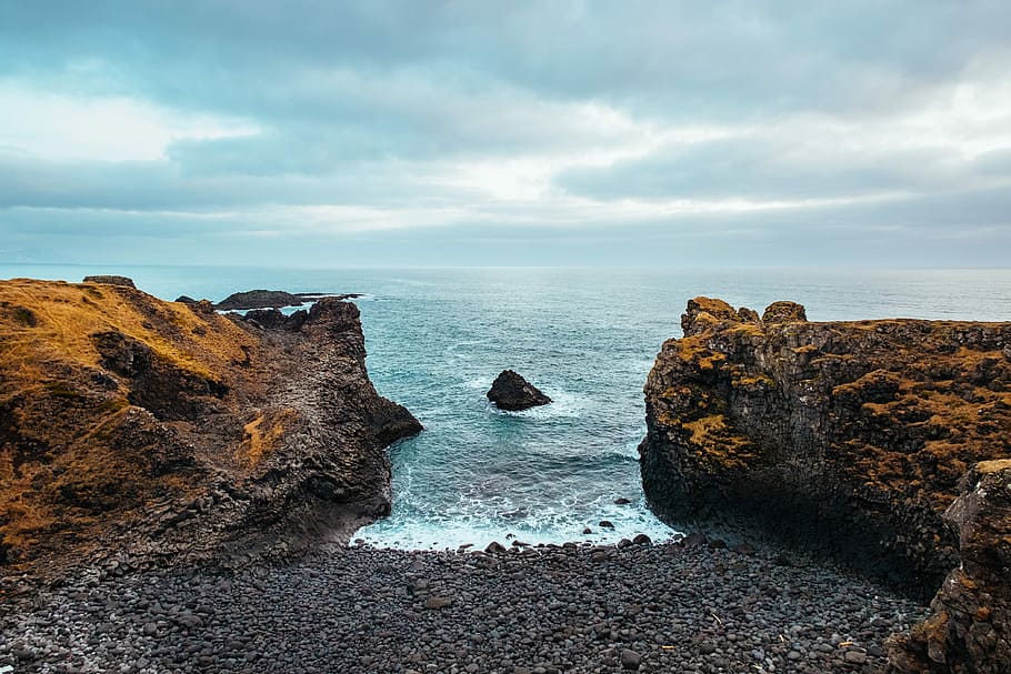 brown mountain cliff bear body of water, body of water between two rocky cliffs HD wallpaper