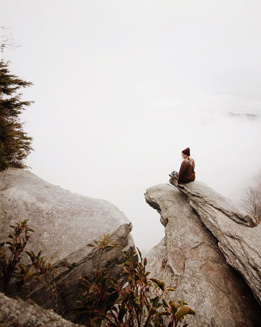 woman sitting on brown rock, woman sitting on cliff near trees HD wallpaper