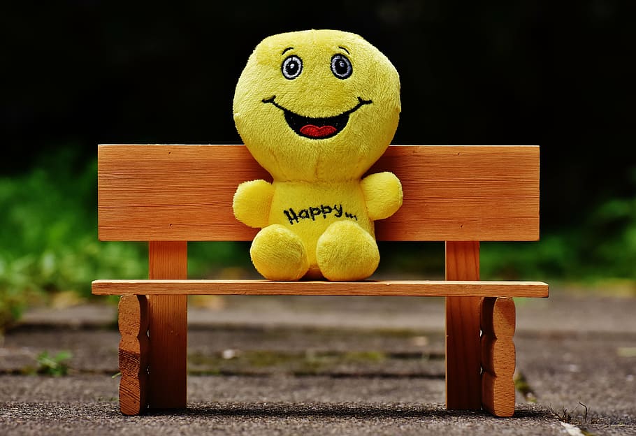 yellow plush toy sitting on bench, smilies, bank, rest, friends