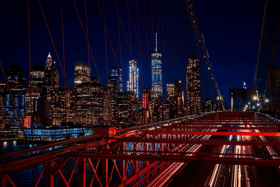 time lapse and light streaks photo of cars on the bridge with high rise buildings as background