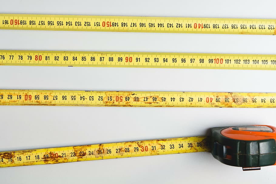 flat lay photography of tape measure on white surface, yellow