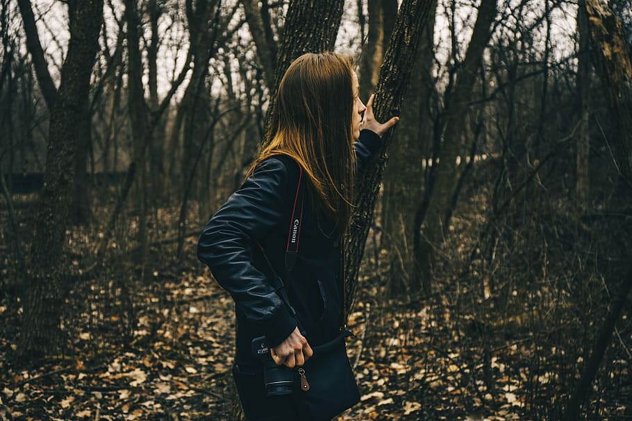 woman in forest holding tree, woman holding tree branch while looking the surrounding HD wallpaper