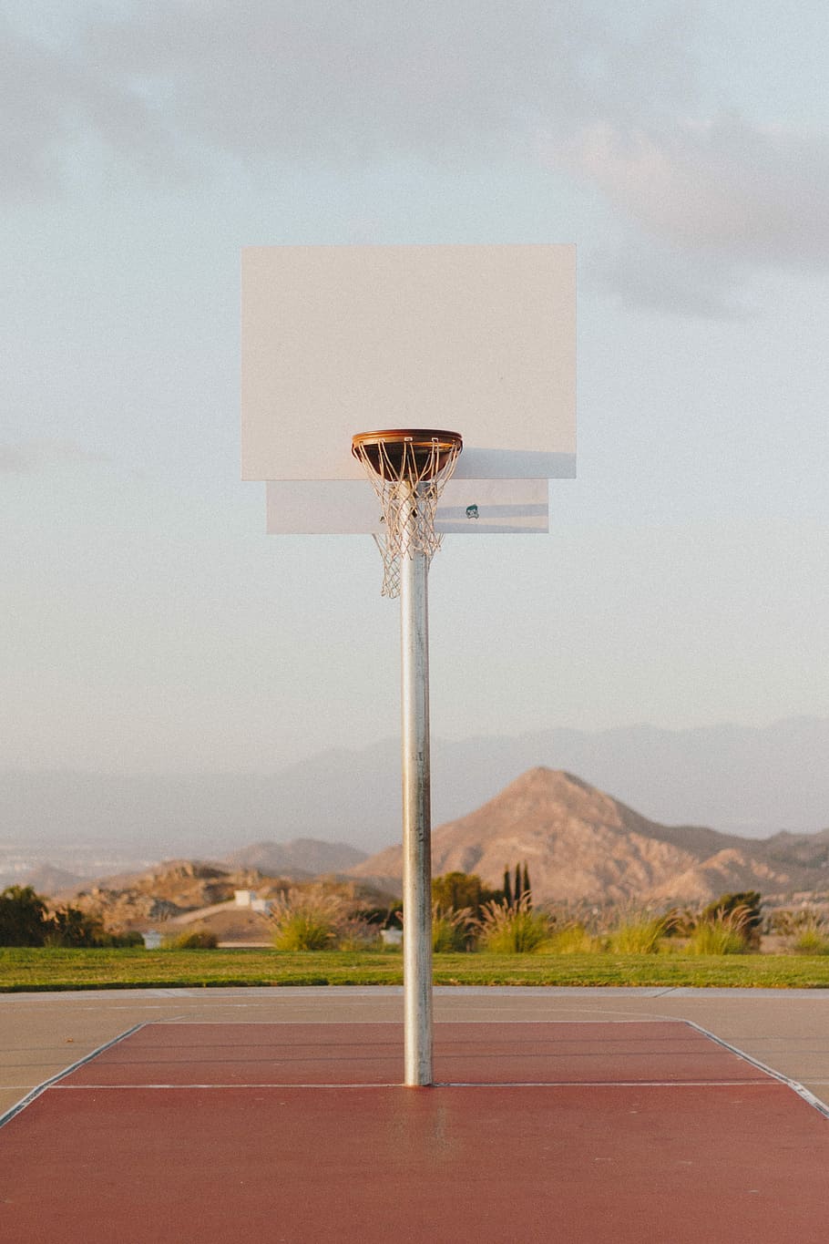basketball court, white and brown basketball system on brown court surrounded with green plants at daytime HD wallpaper
