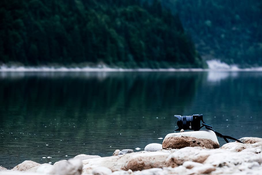 black DSLR camera near body of water, black digital camera on rock facing water at daytime HD wallpaper