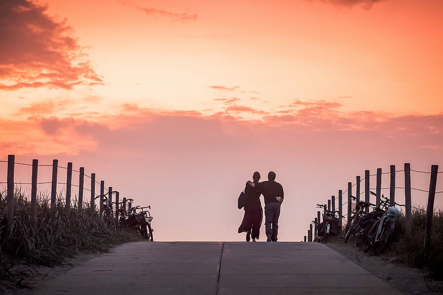 Dutch romantic sunset, couple walking on road during sunset, woman
