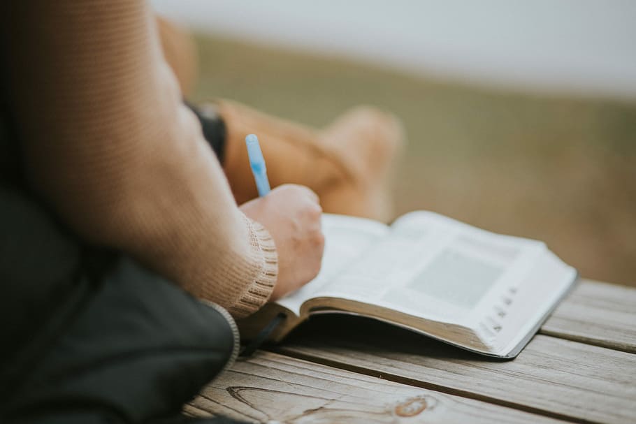 close-up photography of person writing on book page, person writing on book HD wallpaper
