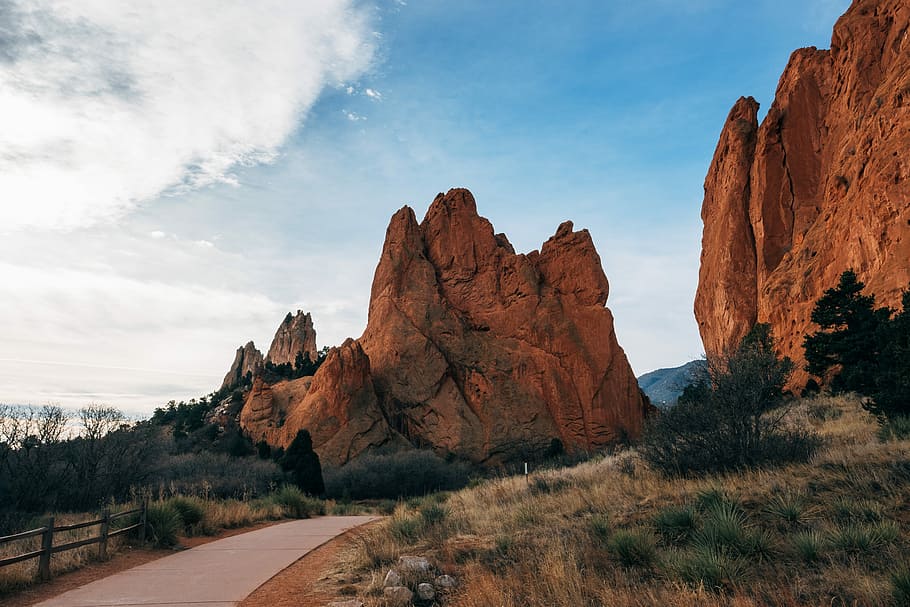 concrete road in the middle two rock formations during daytime, empty road near mountain HD wallpaper