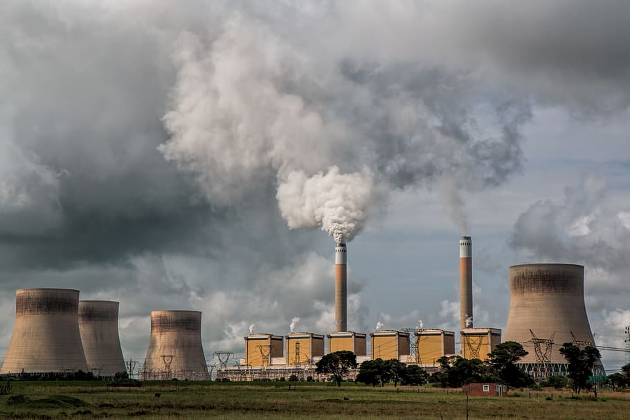 power plant with chimney under grey clouds, pollution, energy
