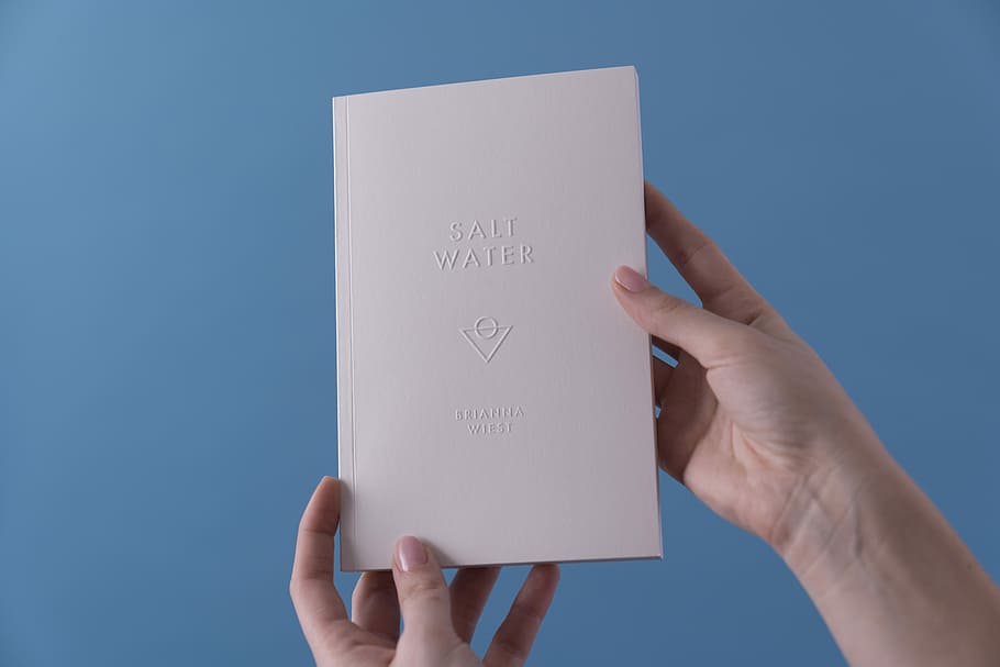 person holding Salt Water book, person showin g white paper, card HD wallpaper