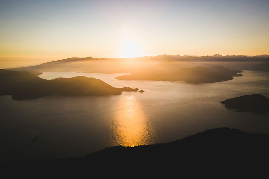 aerial view photo of islands and body of water during daytime, aerial photography of body of water and mountains at golden hour HD wallpaper