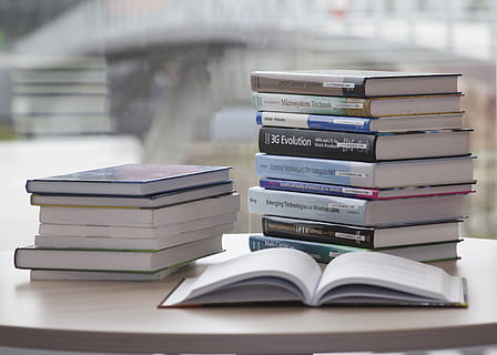 one open book beside pile of books on white table, stack, learn HD wallpaper