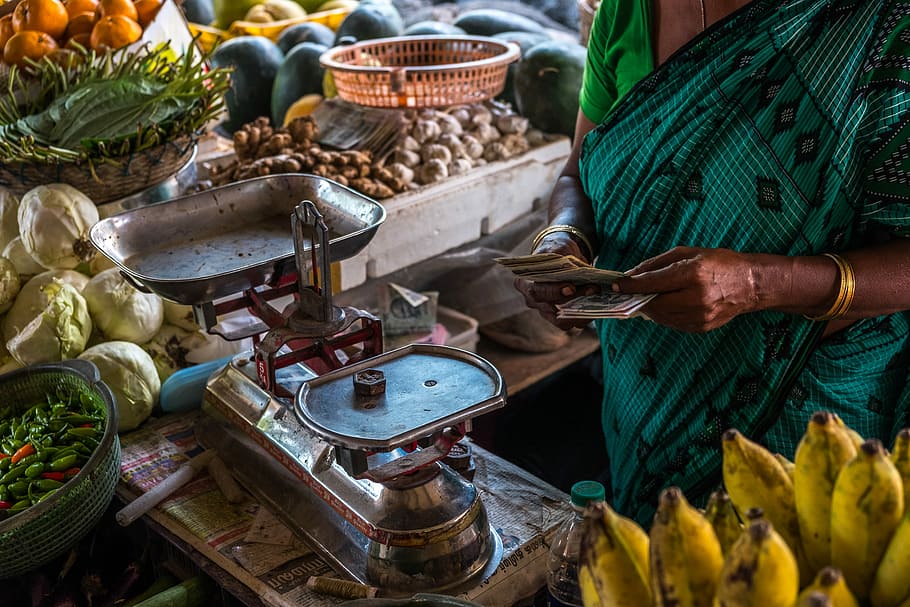 woman in front of stainless steel scale, person holding money in front of balancing scale inside market, HD wallpaper