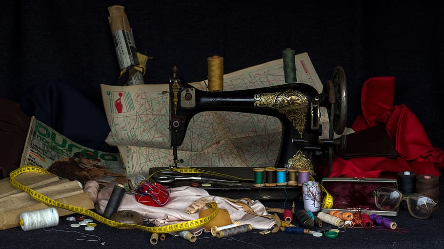 black treadle sewing machine surrounded by assorted items, still life