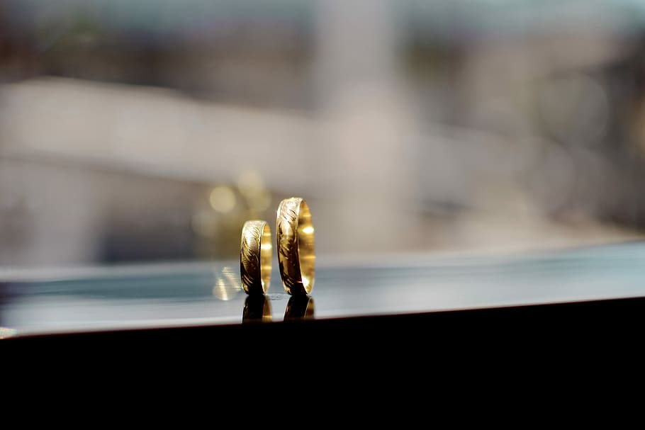shallow focus photography of gold-colored couple rings, two gold-colored band rings against glass HD wallpaper