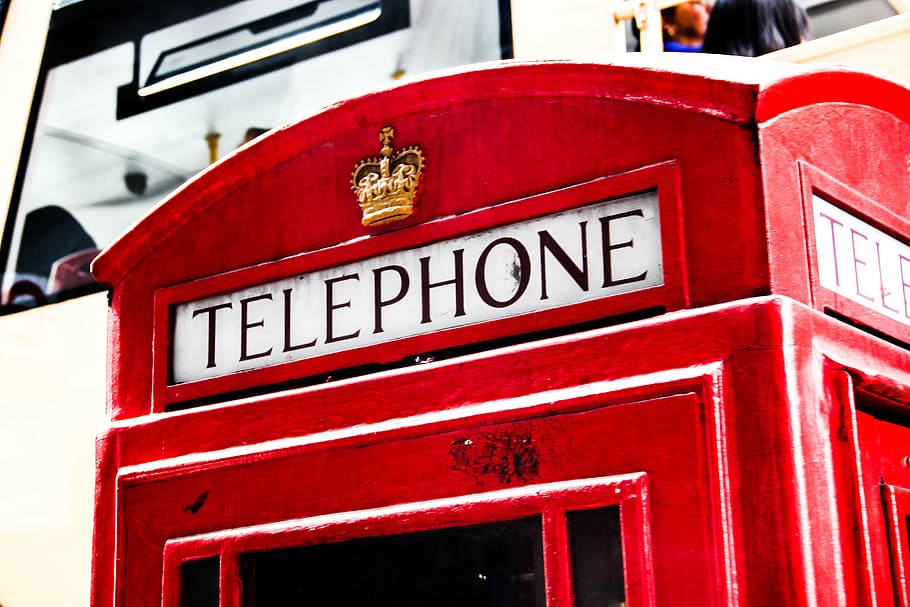 red Telephone station in close-up photography at daytime, phone booth