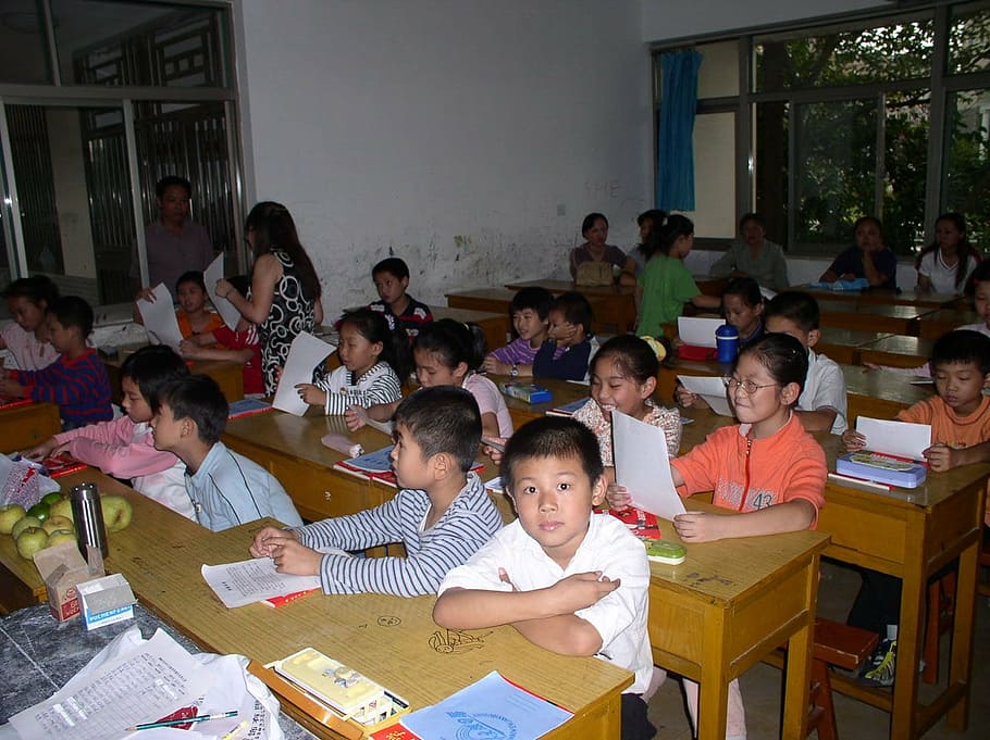 group of children sitting on writing desk, classroom, students