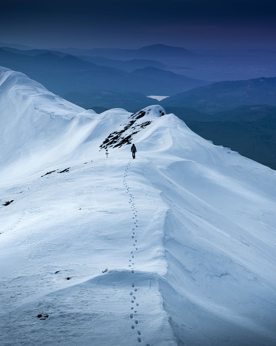 snow-covered land, person walking on top of the mountain during daytime HD wallpaper