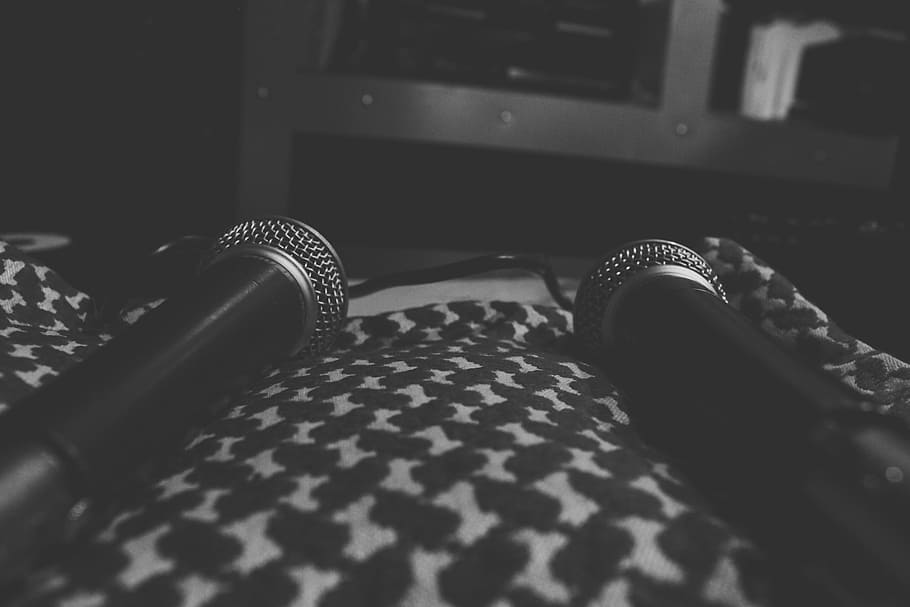 two black microphones on top of black and white textile, music