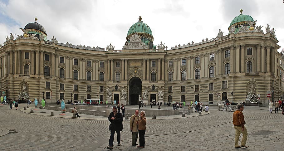 people walking along street near beige concrete building, hofburg imperial palace