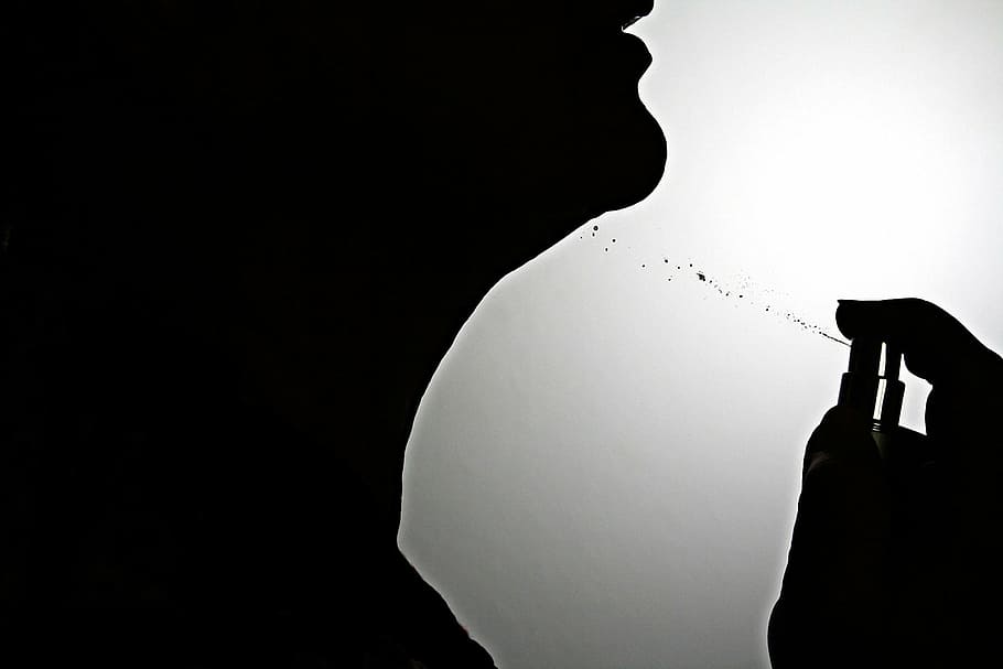 silhouette of person using spray bottle, perfume, sprayer, glass bottle