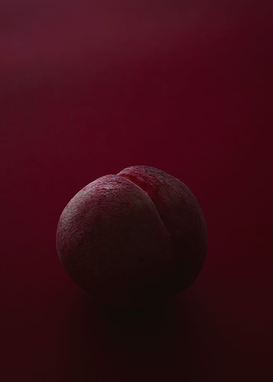 brown ball on red surface, pink fruit, peach, plum, food photography HD wallpaper