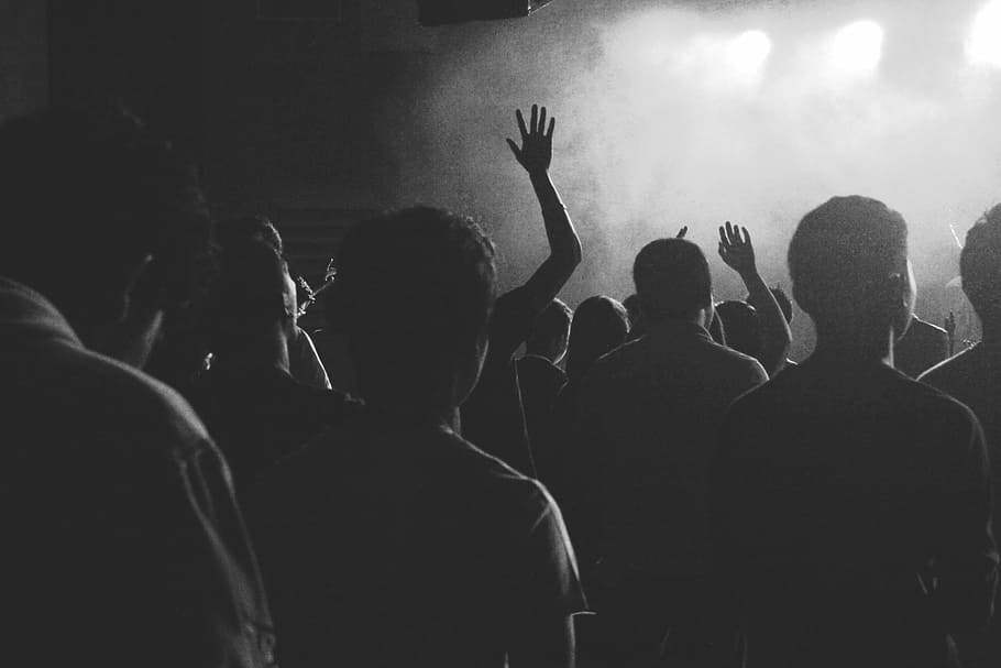 A crowd at a concert, grayscale photography of people gathered inside establishment