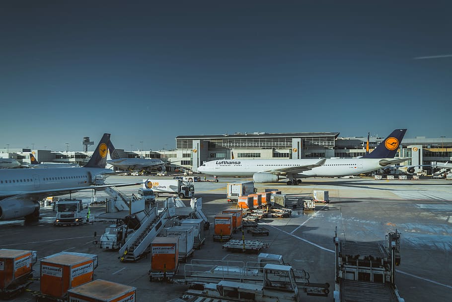 photo of white airliner on port, white passenger planes park on airport at daytime