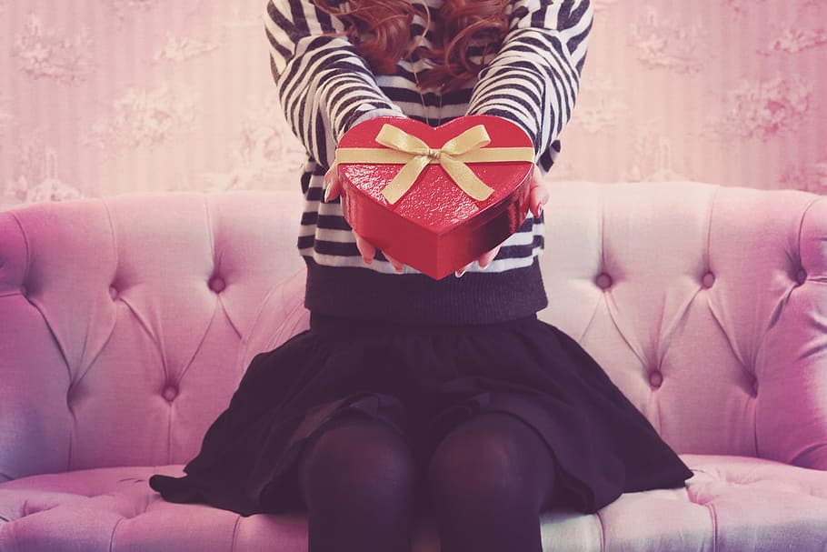 woman holding heart shape gift box, sofa, women, females, indoors HD wallpaper