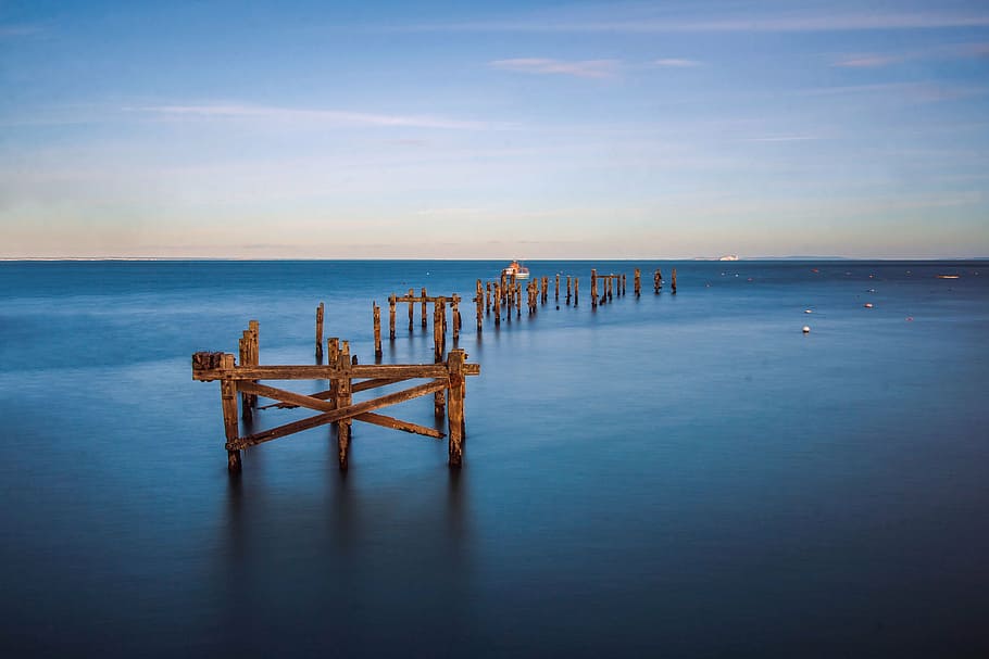 brown wooden poles in body of water, old pier, bay, coast, swanage