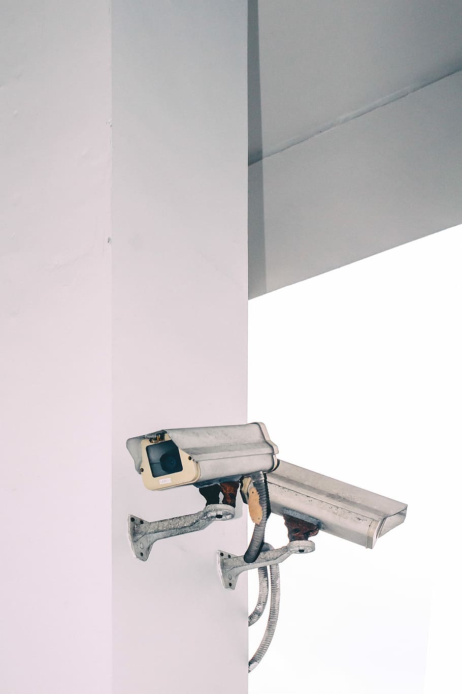 two bullet security camera attached on wall, white CCTV camera on wall