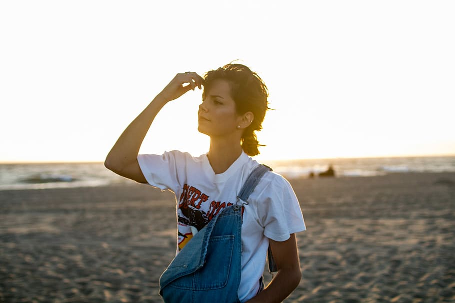 woman standing on seashore holding her head, woman holding forehead HD wallpaper