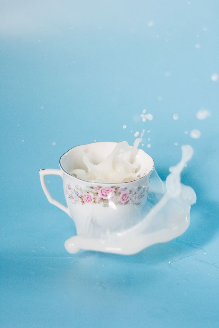 white and pink floral ceramic cup with spilled milk, white and pink floral ceramic teacup with white liquid HD wallpaper