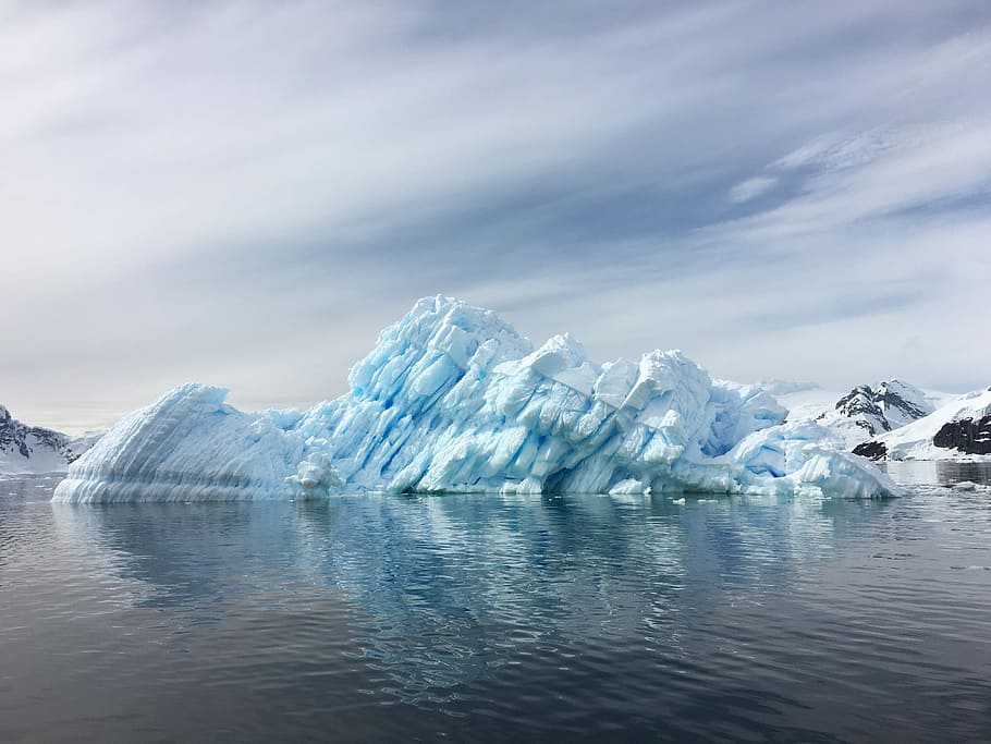 selective focus of white snow butte, white iceberg on body of water under blue sky HD wallpaper