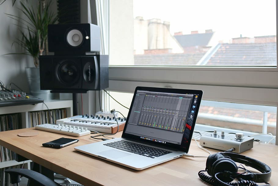 MacBook Pro on table beside headphones, near, black, smartphone
