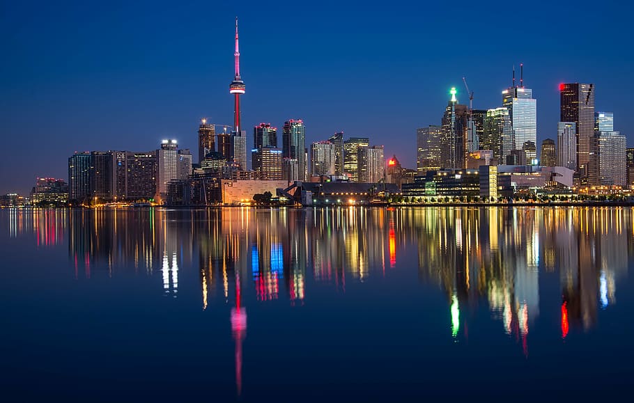 city buildings at night time with reflection on water, can, cn tower
