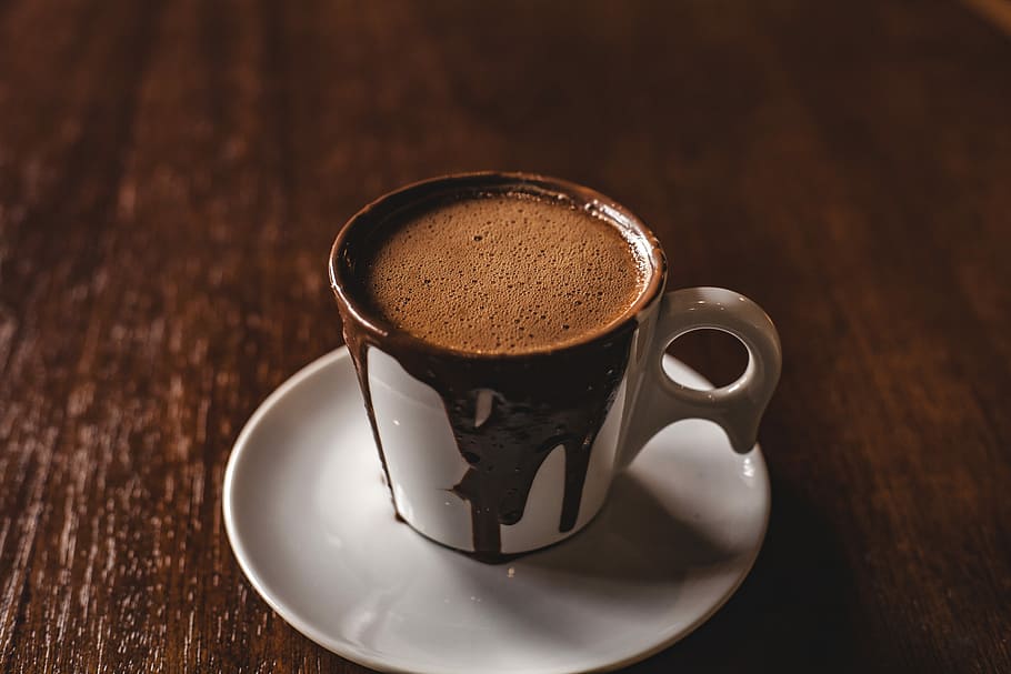 photo of mug with hot choco, white and black mug with coffee on saucer