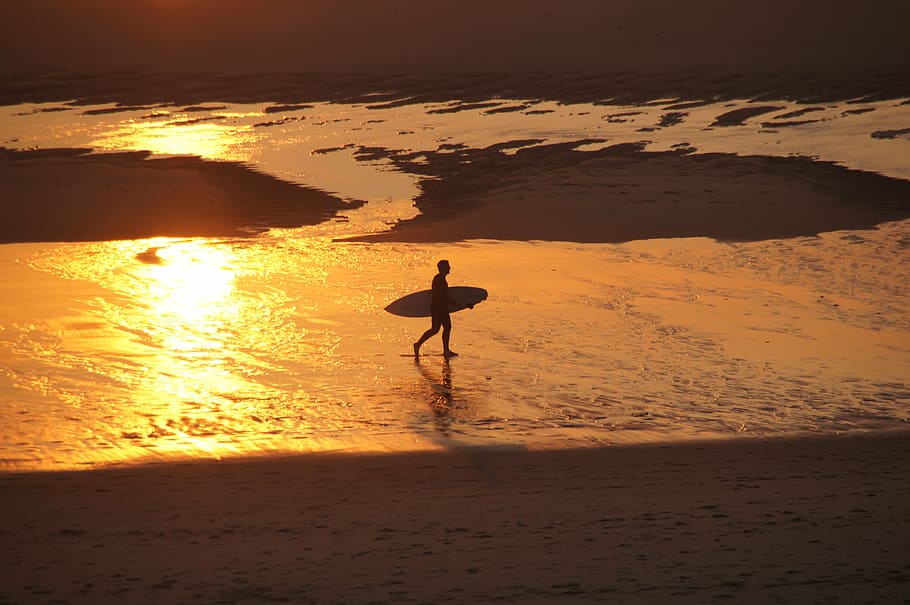 man holding surfboard near seashore during dawn, beach, sunset HD wallpaper