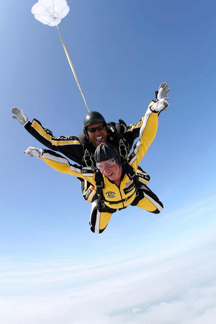 man and woman wearing yellow suit riding parachute above clouds HD wallpaper