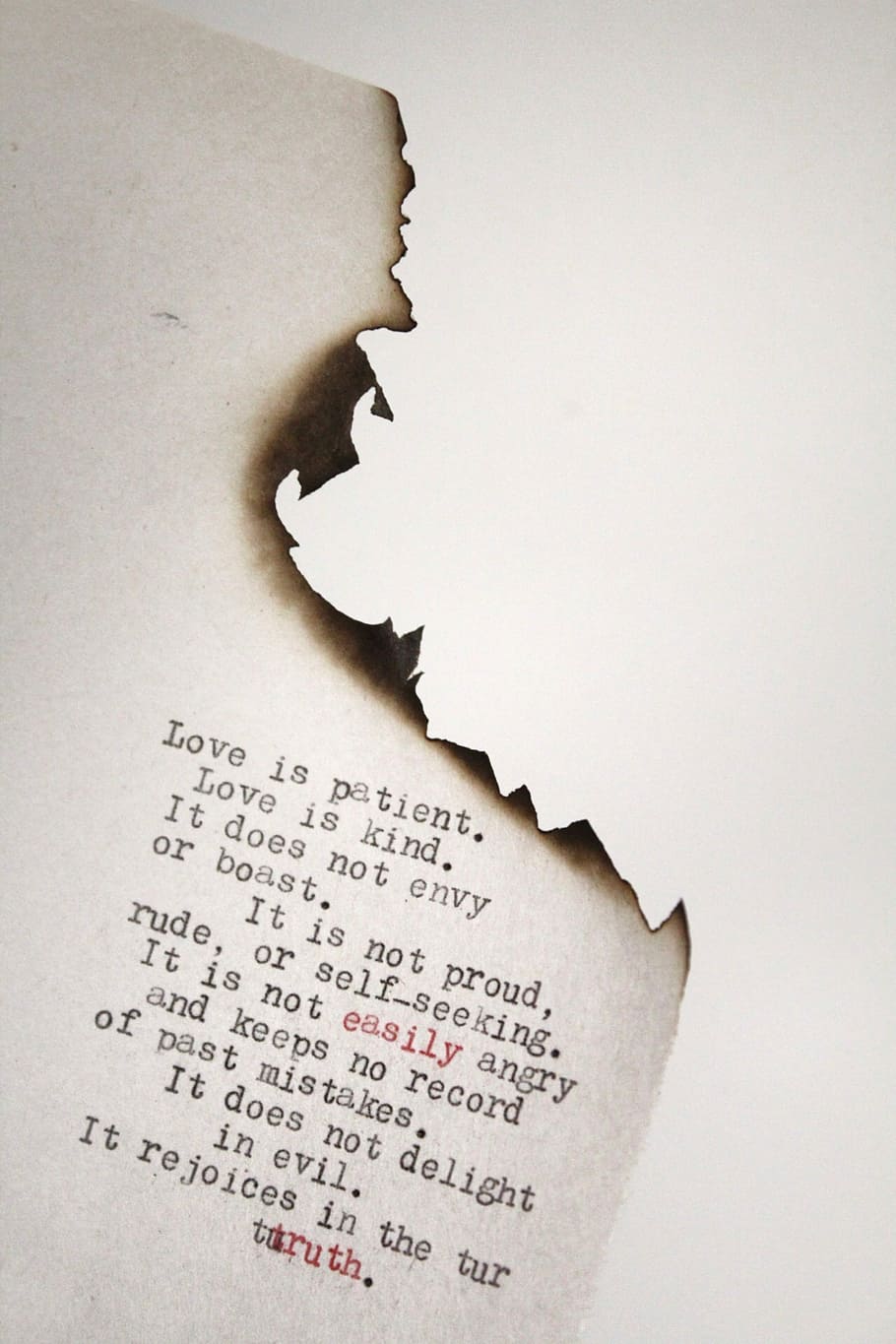 Love is patient Love is kind printed on burned paper, white printed paper