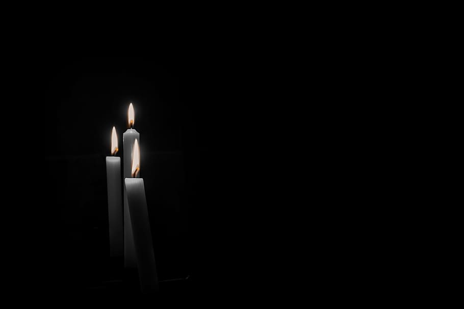 grayscale photography of three white lighted candles, mourning