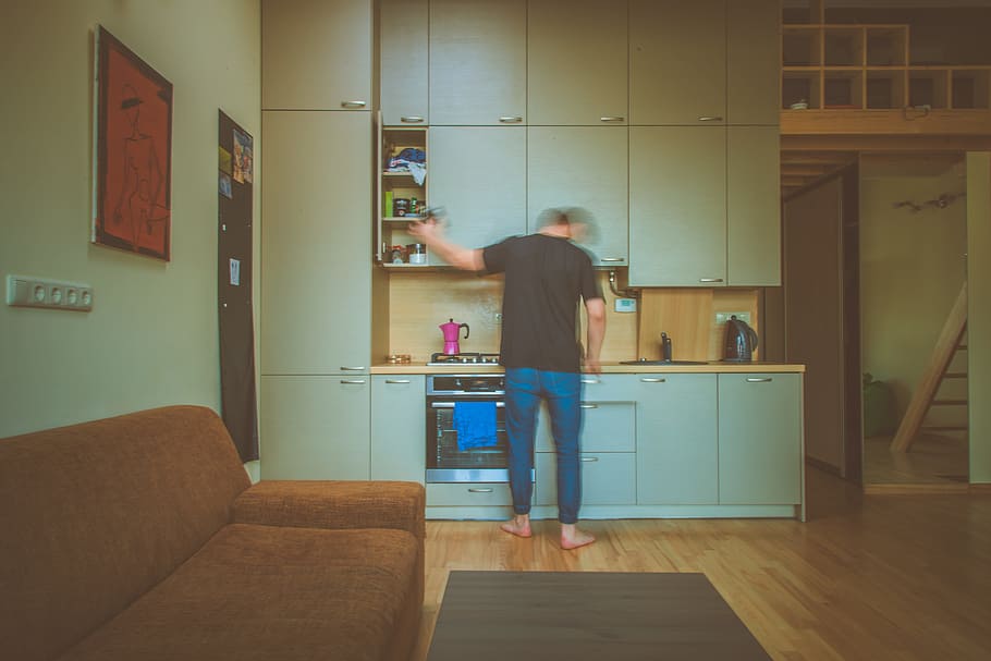 man facing on gray wooden cabinet picking container, photo of man in front of kitchen cabinet opening one door of cabinet HD wallpaper