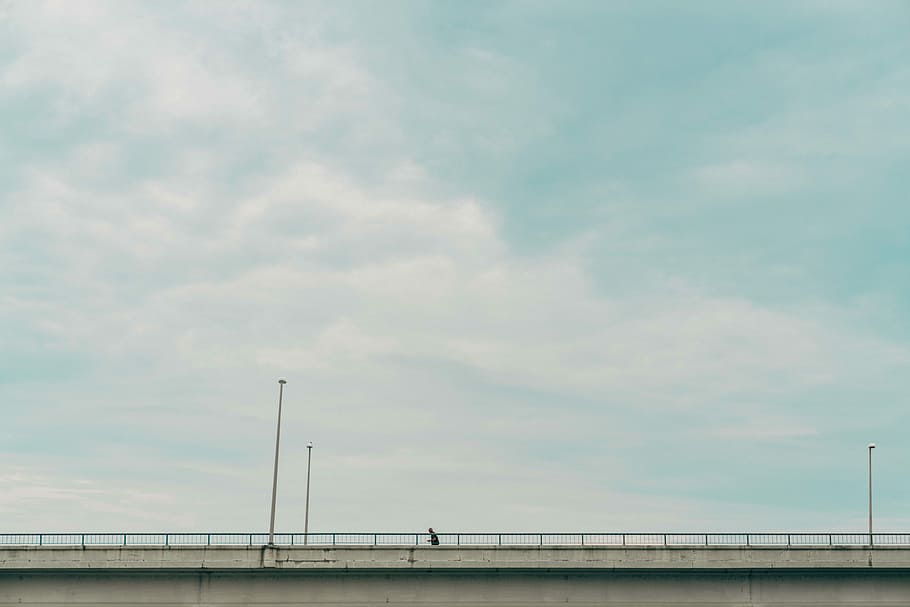 gray suspension bridge under white clouds during daytime, person walking on bridge, HD wallpaper