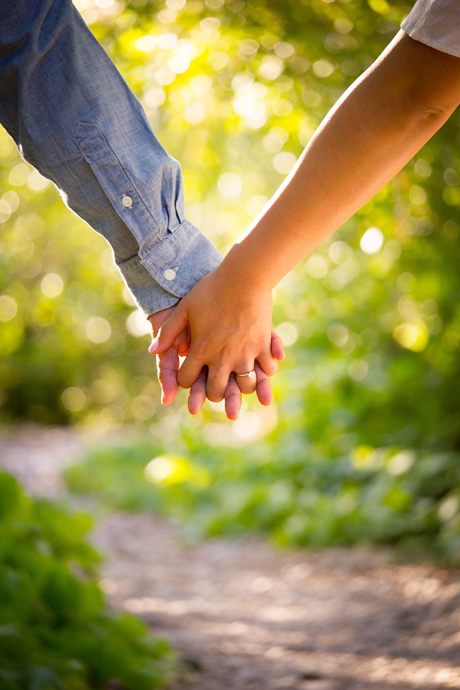 shallow focus photo of man and woman holding hands, holding hands while walking