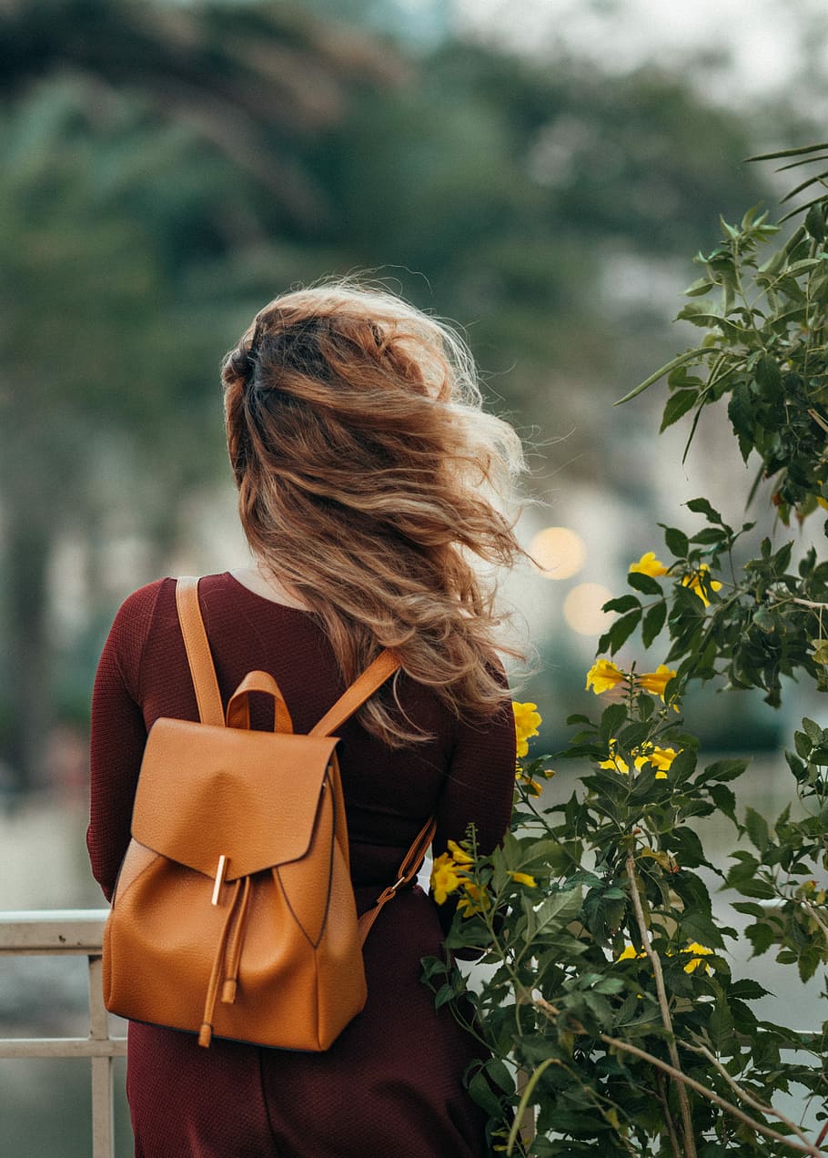 HD wallpaper: woman carrying brown leather backpack, selective focus  photography of woman carrying brown leather backpack beside yellow flowers  | Wallpaper Flare