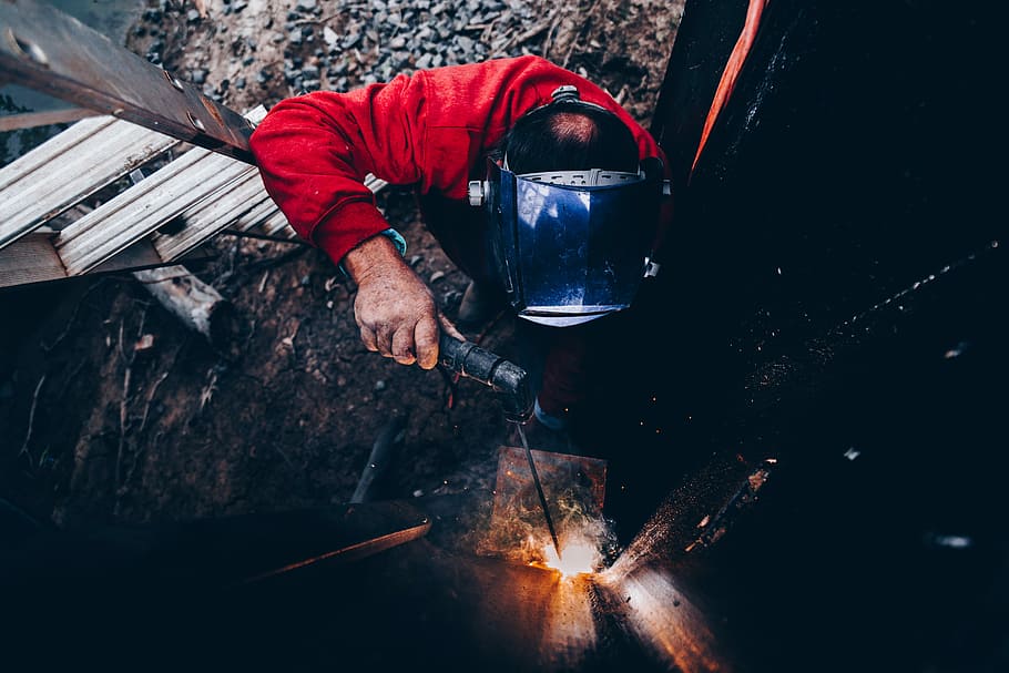 man holding welding machine and wearing welding mask, man using welding machine