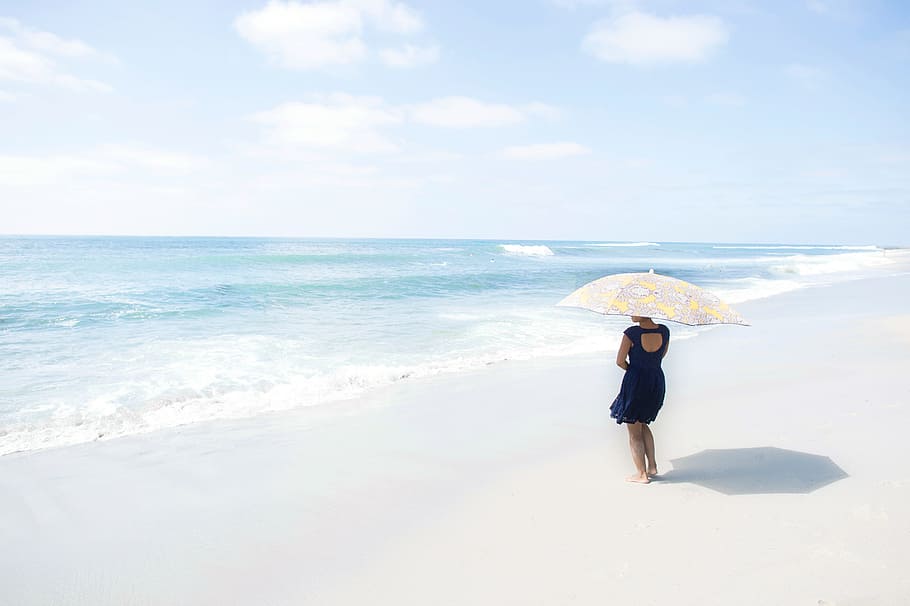 woman wearing black short dress holding umbrella on the seashore HD wallpaper